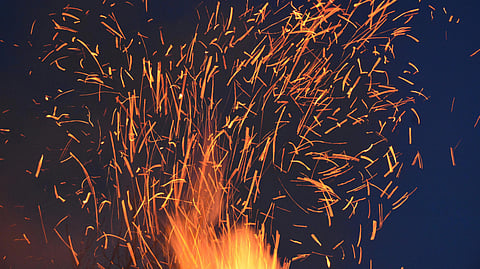 Image of fire crackers bursting in the sky at night.