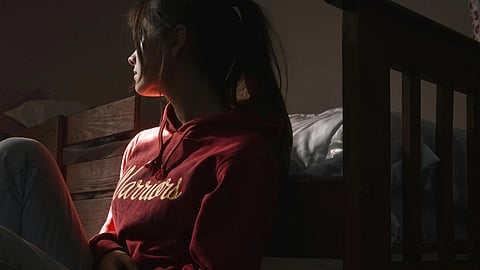 Image of a woman in a red hoodie suffering from addiction.