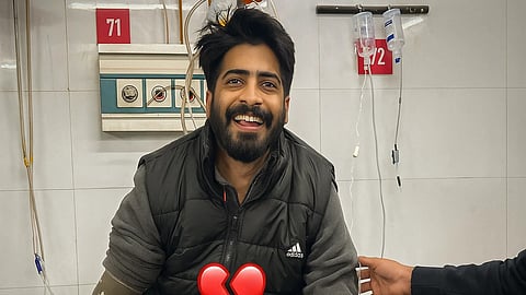 An image of Dr. Tariq‑ul‑Islam in black jacket sitting on a hospital bed with BP machine wrapped around his right hand. 