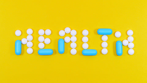 Image of 'HEALTH' written with tablets over a yellow background.