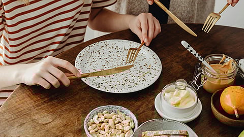A woman and a girl enjoy breakfast together at a table, sharing a moment of connection and conversation.