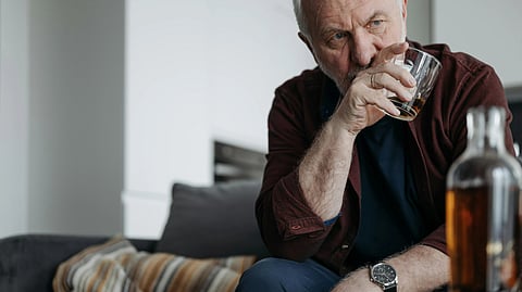 An older man savoring a glass of whiskey, reflecting a moment of relaxation and contemplation.