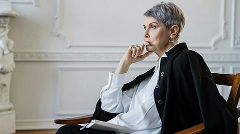 An image of a woman sitting in a chair.