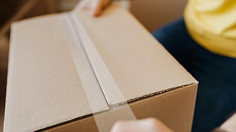 Image of a person putting tape on a parcel.
