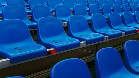 A row of blue seats arranged in a stadium, ready for spectators to enjoy an event.