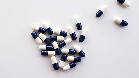 Image of capsules of navy blue and white color.