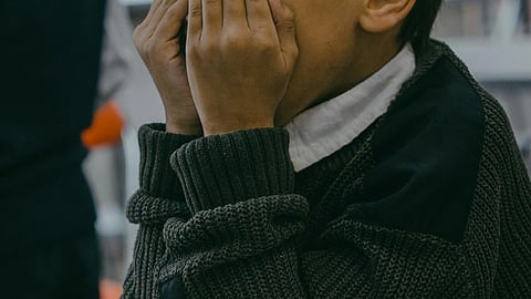 Image of a child wearing a sweater and a shirt.