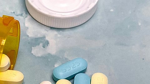 Image of tablets of cholesterol over a light blue surface.