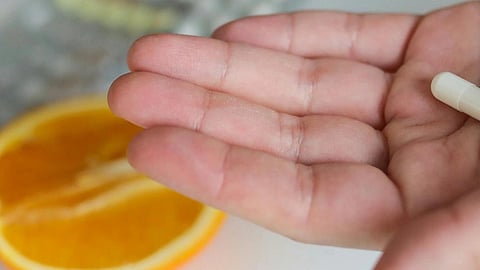 Image of a woman having pills in her hand.