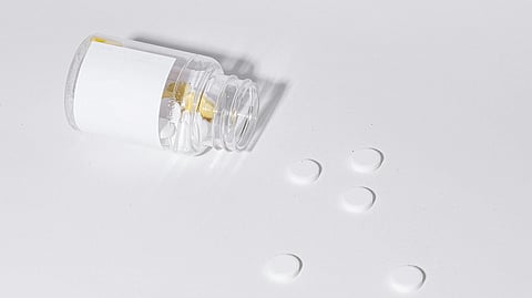 A bottle of pills resting on a clean white surface, showcasing its label and contents clearly.