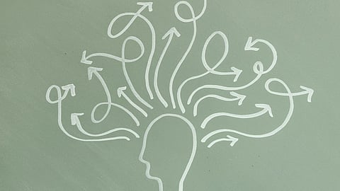 A drawing of a brain with multiple arrows radiating outward, symbolizing thoughts or ideas being generated.