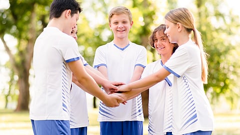A diverse group of young people holding hands in a circle, symbolizing unity and friendship.
