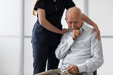 nurse consoling crying old man
