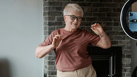An older woman joyfully dancing in front of a camera, showcasing her vibrant spirit and enthusiasm.