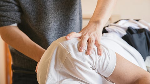 An image of a physiotherapist and patient during a therapy session.