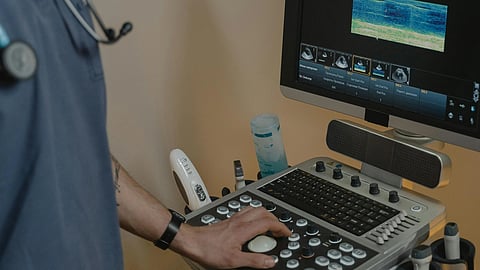 An image of an uktrasound machine and a medical staff.