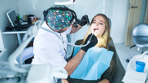 Image of a dentist working on a female patient.