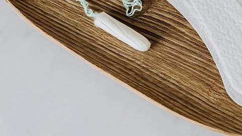 Image of a pad and tampons on a wooden table.