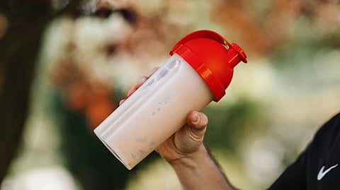 Image of a protein shaker having a red cap.