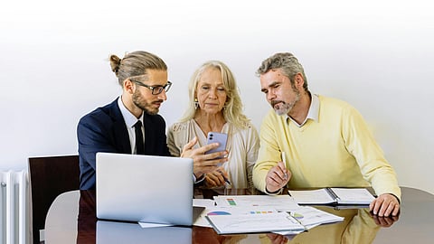 Image of an agent teaching an older couple about Medicare plans.