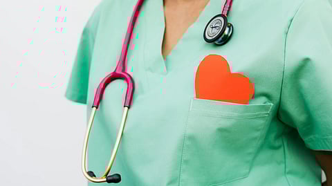 An image of a doctor with a stethoscope and a heart cut out.
