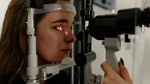 A woman examines her eye during an eye exam.