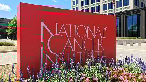 National Cancer Institute sign displayed in front of a modern building.