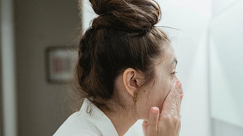 An image of a girl washing her face with soap.