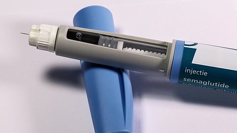 A blue and white syringe featuring a white tip, designed for medical use.