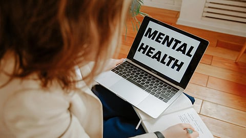 An image of online therapy with a girl with a laptop on her lap.