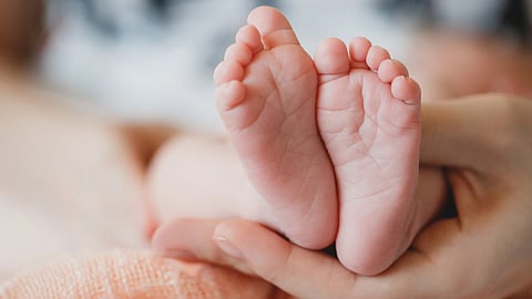 Image of a newborn's feet being held by his mother.