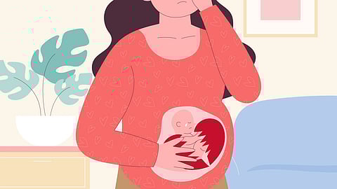 Pregnant woman holding her stomach in pain, tears streaming down her face, expressing distress and discomfort.