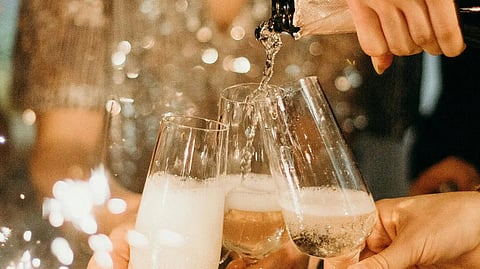 Image of a group of people joyfully toasting with champagne flutes at a festive party celebration.