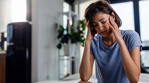 Image of a woman wearing a blue t-shirt in very stressed mood.