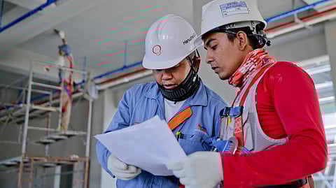 An iamge of 2 workers on site wearing safety gear.