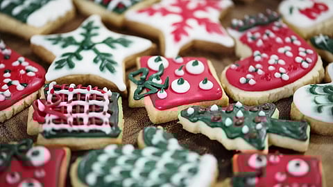 A festive assortment of Christmas cookies shaped like stars, stockings, and trees, decorated with red, white, and green icing