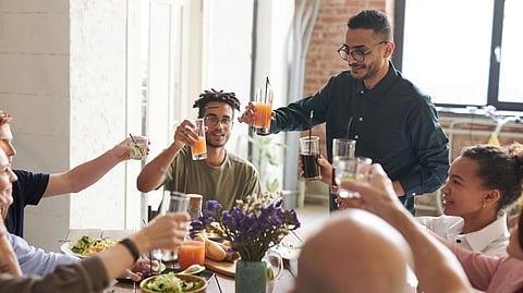 Image of a family having dinner at the table while hosting a guest with an eating disorder.
