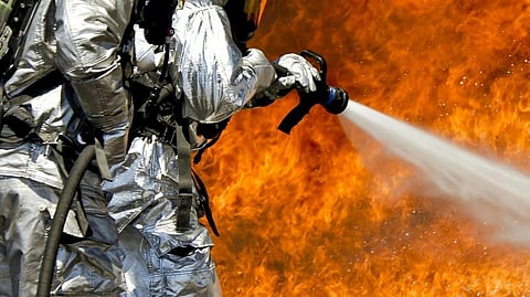 Image of two firefighters trying to put out the fire.