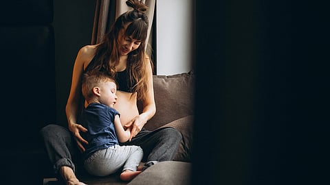 An image of a woman and her son sitting together on a couch.
