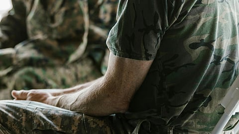 Image of a veteran sitting with his hands gently clasped together.