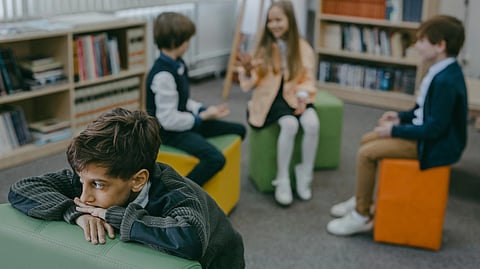 An image of a group of kids and one kid alone.