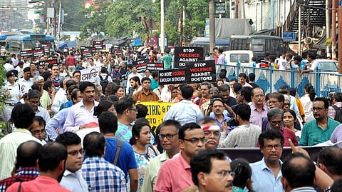 A large crowd protesting against the violence against doctors with placards.
