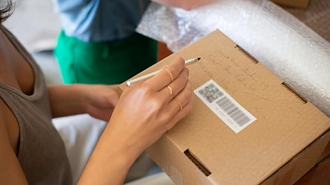 Image of a woman checking a box of medical equipment using a barcode.