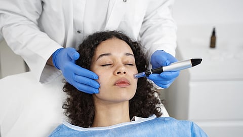 A woman getting a cosmetic procedure done on her face in a clinic. 