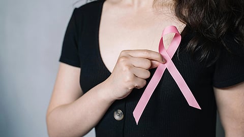 Image of a woman wearing a black T-shirt with a pink ribbon.