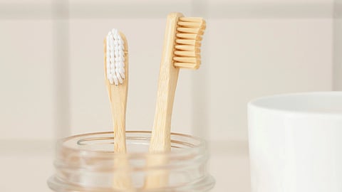 Image showing two bamboo toothbrushes in a glass jar