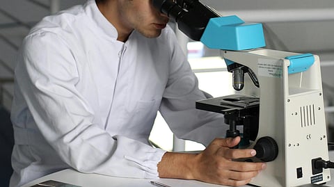 Image of a scientist working in a laboratory using a microscope.