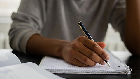 An image of a boy writing an exam.