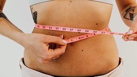An image of measuring tape over stomach.
