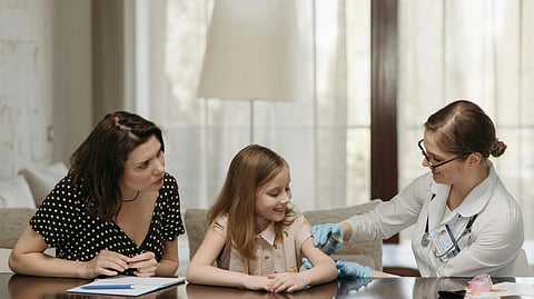 An image of a child, her parent and a doctor.